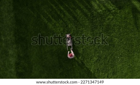 Professional worker with lawn mower mows the grass, top view. Copy space