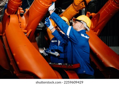 Professional worker maintenance machine robotic arms industrial machinery. Technician engineer checking safety of machine and maintenance fix robotic arms.