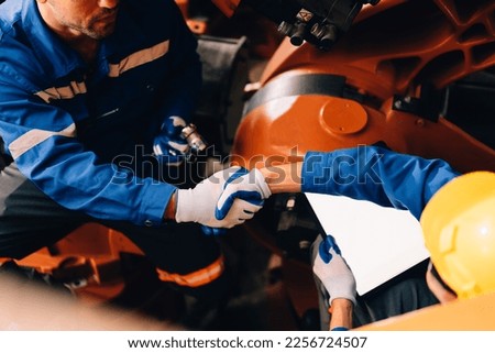 Professional worker maintenance machine robotic arms industrial machinery. Technician engineer checking safety of machine and maintenance fix robotic arms.