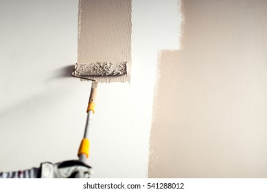 professional worker plastering wall  painting and paint brush decoration interior walls