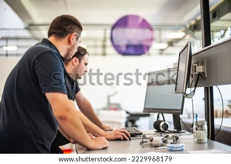 Professional worker printmaker technician operator works in printing press hall and printshop office with many different type of machine
