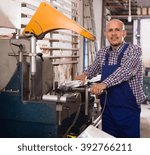 Professional worker toiling on a machine in PVC shop