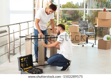 Professional workers disassembling rack in office. Moving service
