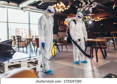 Professional workers in hazmat suits disinfecting indoor of cafe or restaurant, pandemic health risk, coronavirus - Shutterstock ID 1733297285