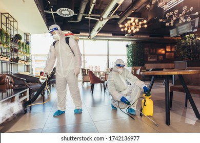 Fachkräfte in Gefahrenanzügen zur Desinfektion von Café oder Restaurant im Haus, Pandemie-Gesundheitsrisiko, Coronavirus