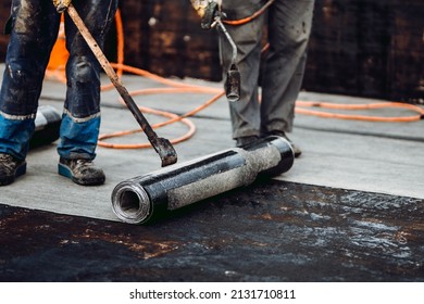 Professional Workers Waterproofing House Construction Site. Worker Rolling Membrane