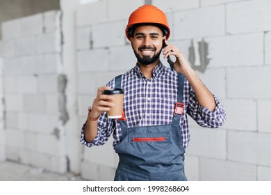 Professional Young Bricklayer Talking By Smartphone On The Construction Site