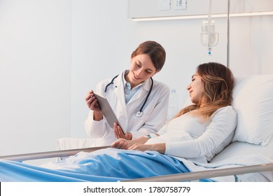 Professional young female doctor Discussing Records With Female Patient Using Digital Tablet at the hospital  - Powered by Shutterstock