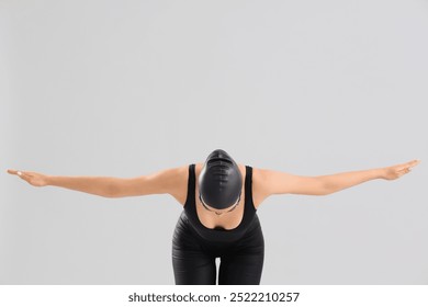 Professional young female swimmer stretching on grey background - Powered by Shutterstock