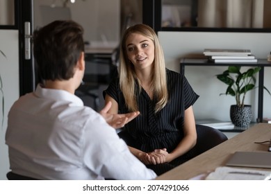 Professional young male hr manager holding job interview with motivated millennial blonde female candidate, discussing previous working experience. Happy two colleagues briefing new project ideas.