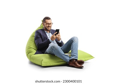 Professional young man seated on a bean bag smiling and looking at a smartphone isolated on white background  - Powered by Shutterstock