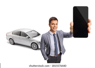 Professional young man with a silver car holding a mobile phone isolated on white background