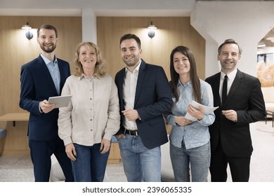 Professionals, businesspeople, corporate staff members portrait. Five young and middle-aged employees posing standing in modern office smile look at camera. Business ambitions, company representatives
