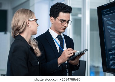 IT Professionals Coding and Reviewing Data on a Computer Screen During a Teamwork Collaboration Session in a Modern Office. Focused Business and Technology Professionals in Corporate Attire - Powered by Shutterstock - Get 15% off with code: PIKWIZARD15