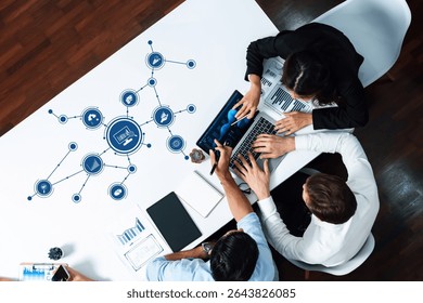 Professionals collaborate on data analysis at a modern office table, illustrating digital connectivity through technology icons and emphasizing teamwork for business insights. Amity