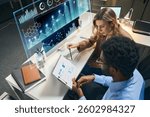 Professionals Collaborating Using Advanced Data Analytics and Graphic Tools at a Modern Workspace