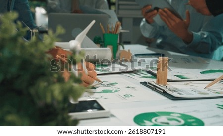Professionals in a collaborative workspace focus on sustainable development projects. Green technology and eco-friendly materials enhance team brainstorming and productivity. SACTR