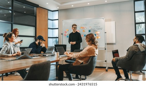 Professionals in a diverse group collaborate in a boardroom, engaging in a lively brainstorming session. They discuss ideas, showcasing teamwork and creativity. This successful tech company employs ef - Powered by Shutterstock