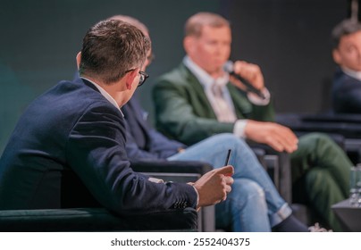 Professionals engage in a panel discussion at business conference. Focused conversation emphasizes collaboration and insights within industry context. - Powered by Shutterstock