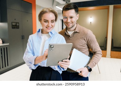 Professionals engaged in a collaborative discussion using a tablet in a modern workspace setting