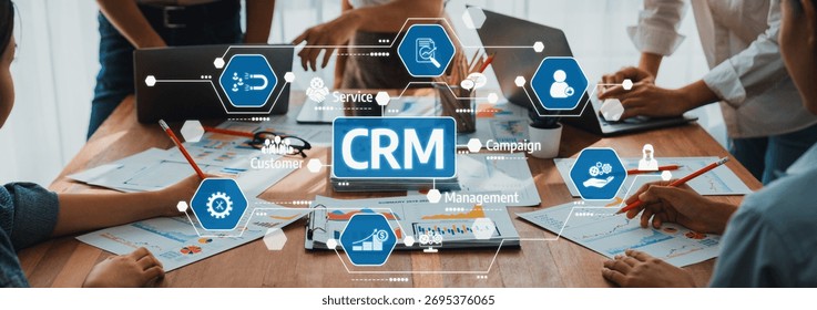 Professionals engaged in a collaborative workspace, utilizing CRM tools and digital interfaces to strategize and plan for improved business outcomes and innovation efforts. Amity