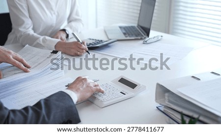 Professionals examining financial data and stacks of paperwork, performing a thorough audit and detailed investigation. Audit and taxes in business