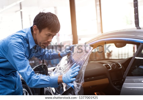 Professionals install car paint protection,\
protect coating installation in the car\
glass.