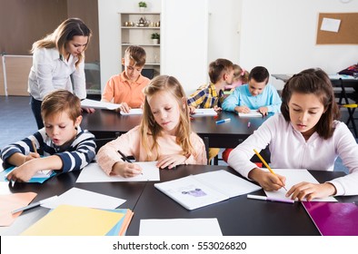 Professor And Elementary Age Children In A Classroom At A School 