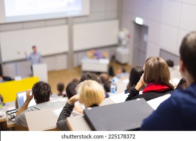 Professor giving presentation in lecture hall at university. Participants listening to lecture and making notes. - Shutterstock ID 225178372