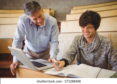 Professor Helping A Student In Classroom At College