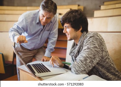 Professor Helping A Student In Classroom At College