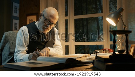 Professor working in his office, he is writing and reading books, research and knowledge concept