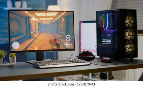 Professsional gaming empty room studio with neon lights and RGB powerful computer, keyboard and mouse. FPS shooter video game on pc display, stream chat on television - Shutterstock ID 1936870411
