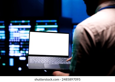 Proficient developer conducting routine auditing of high tech facility servers using mock up laptop to optimize its lifespan, prevent damages and ensure uninterrupted computing power