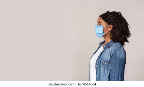 Profife Portrait Of Scared African American Woman Wearing Protective Medical Mask And Looking Aside At Copy Space On Light Studio Background, Panorama