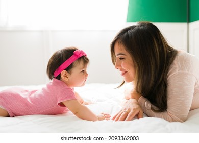 Profile Of An Adorable Baby Girl And Caucasian Young Mother Smiling While Resting In The Bedroom 