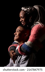 Profile Of An African American Mother And Her Teenage Son On A Black Background With A Big Smile.