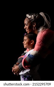  Profile of an African American mother and her young daughter on a black background with a big smile. - Shutterstock ID 2152295709