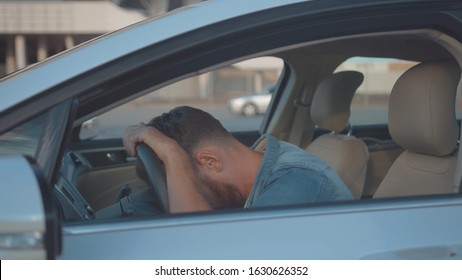 Profile Of Annoyed Male Driver Sitting In The Car Talking By Phone. Young Man Calling Car Support Services Shouting On Smartphone. Car Trouble.