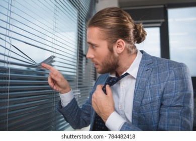 Profile Of Attentive Boss Spying On The Office Window. He Is Holding Tie With His Hand