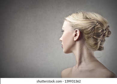 profile of beautiful blonde woman on gray background