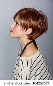 Profile Of A Beautiful Woman With Red Lips And Short Feathered Red Hair In Modern Bob Over Studio Background