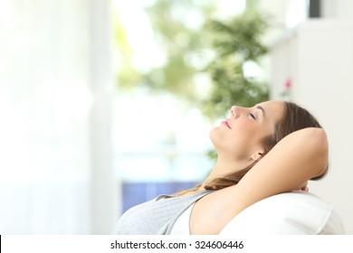 Profile of a beautiful woman relaxing lying on a couch at home