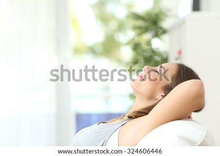 Profile of a beautiful woman relaxing lying on a couch at home