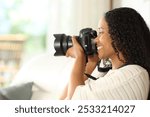 Profile of a black photographer taking photos with dslr camera at home