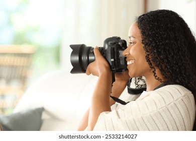 Profile of a black photographer taking photos with dslr camera at home - Powered by Shutterstock