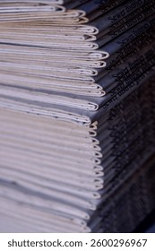 profile edge view of stack of printed and folded newspapers 