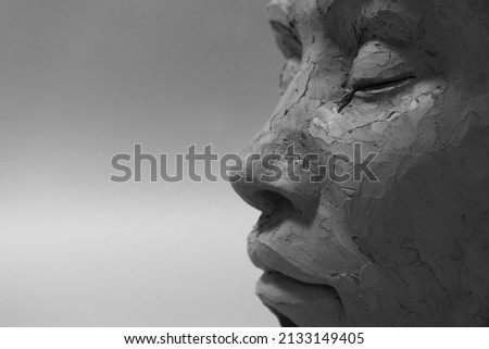 Profile face sculpture. Black and white style. Female clay portrait with closed eyes.