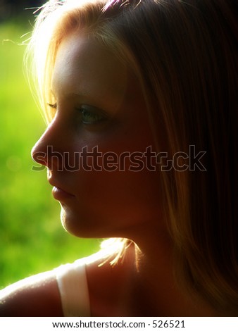 Profile of Girl in countryside, backlit.