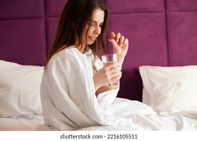 Profile Of Happy Girl Taking Omega 3 Pill On Bed In Morning At Home